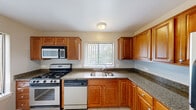 Located at 4233 N Bloomington Ave in Arlington Heights, Illinois, this single-floor residence offers a clean, functional layout filled with natural light throughout. The open living area features neutral-toned carpet, a ceiling fan, and multiple windows dressed with vertical blinds that invite abundant daylight. A sliding glass door provides direct access to an outdoor space, further enhancing the sense of openness. The kitchen is thoughtfully designed with warm-toned wood cabinetry, granite-look countertops, tile flooring, and stainless steel appliances including a gas range, built-in microwave, and dishwasher. A window above the sink frames a pleasant outdoor view, keeping the space bright and airy. The bedrooms are generously sized, each finished with carpet flooring and neutral wall tones, offering versatile living spaces. One bedroom features a direct connection to a bathroom, adding a level of convenience. The bathroom includes a wood-vanity with a white countertop, large mirror, and well-lit vanity lighting. Throughout the home, consistent neutral tones and clean finishes create a cohesive, move-in-ready atmosphere well-suited to a variety of lifestyles.