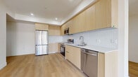 Located at 7050 Hawthorn Ave in the heart of Hollywood, Los Angeles, this thoughtfully designed 4-bedroom, 4-bathroom unit offers a clean, modern aesthetic across a well-organized single-floor layout. Light wood-tone flooring flows throughout the space, complementing the bright white walls and recessed lighting that give every room an airy, contemporary feel.

The open-concept living, dining, and kitchen area serves as the heart of the home. The kitchen is outfitted with flat-front light wood cabinetry extending to the ceiling, a textured white tile backsplash, sleek quartz countertops, and a full suite of stainless steel appliances including a refrigerator, range, microwave, and dishwasher. The living area opens to a private balcony through sliding glass doors, offering views of the surrounding Hollywood streetscape and filling the space with natural light.

Each of the four bedrooms features light wood flooring, recessed lighting, and dedicated closet space with mirrored sliding doors. The primary bedroom provides a generous footprint with ample storage. The four bathrooms are finished with large-format stone-look tile floors, glass-enclosed walk-in showers with tile surrounds, floating wood vanities, and clean chrome fixtures. Additional conveniences include in-unit laundry and multiple hallway closets for extra storage throughout.