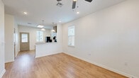 Located at 5095 Big Lake Rd in Lake Charles, Louisiana, this one-bedroom, one-bathroom unit offers a clean, modern design throughout its efficiently arranged single floor. Warm luxury vinyl plank flooring flows seamlessly through every room, complementing the crisp white walls and creating a bright, cohesive aesthetic.

The open-concept living room is a welcoming space, enhanced by multiple windows with blinds that invite generous natural light, a ceiling fan with integrated lighting, and recessed lighting overhead. A glass-paneled front door further brightens the room.

The kitchen is well-equipped with taupe shaker-style cabinetry, light granite countertops, black appliances including a range with overhead hood and a full-size refrigerator, and a skylight that adds additional natural illumination. A secondary door provides convenient exterior access directly from the kitchen.

The bedroom offers a comfortable, quiet retreat with dual windows that provide outdoor views and ample natural light, along with double doors leading to a spacious closet.

The bathroom is designed with accessibility in mind, featuring multiple grab bars positioned around the toilet area and a granite-topped vanity. The consistent flooring and neutral palette carry through, maintaining the unit's clean and modern character throughout.