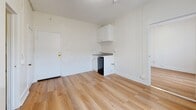 Located at 729 S Union Ave in the heart of Los Angeles, CA, this single-floor unit offers a practical and efficiently designed layout across two living areas and one bathroom. The space is finished with light-toned hardwood flooring throughout, lending warmth and visual continuity to the interior.

The main living area serves as the entry point and features a compact kitchenette along one wall, equipped with white cabinetry, a small sink, tile backsplash, and under-counter refrigerator. White walls and a textured ceiling keep the space feeling clean and bright. A second living area provides additional flexible space and is distinguished by large windows fitted with vertical blinds that allow diffused natural light to fill the room. A classic white cast-iron radiator is present in both living areas, reflecting the building's character and providing a functional heating solution.

The bathroom is efficiently laid out, featuring a walk-in shower with white subway tile surround, chrome fixtures, a toilet, and towel bars — all finished in a clean, all-white palette with hardwood flooring underfoot. Throughout the unit, crisp white walls, clean trim, and consistent flooring create a cohesive, understated aesthetic well-suited for urban living in the Westlake neighborhood of Los Angeles.