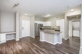 Located in San Diego's University City neighborhood, this one-bedroom, one-bathroom residence offers a well-designed layout across a single floor. The open-concept kitchen and living area serves as the heart of the home, where wood-style flooring flows seamlessly underfoot. The kitchen is outfitted with stainless steel appliances — including a refrigerator, range, and microwave — complemented by granite countertops, a granite-topped breakfast bar, and crisp white cabinetry that provides ample storage. Track lighting adds a modern touch overhead. The living area transitions to plush carpet and is anchored by a sliding glass door fitted with vertical blinds, opening to a private outdoor space and allowing natural light to fill the room. The generously sized bedroom features soft carpet, a ceiling fan with light, a window with exterior views, and direct access to a spacious walk-in closet equipped with wire shelving and hanging rods. The bathroom is finished with wood-style flooring, a granite-topped vanity with white cabinetry, and a full tub-shower combination. A hallway connects the key areas of the home, completing this functional and comfortable San Diego residence.