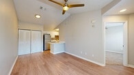 Located at 2802 Cheval Street in Orlando, FL, this single-floor unit offers a well-designed layout that maximizes every square foot. The open-concept living and kitchen area is a standout feature, anchored by soaring vaulted ceilings and a ceiling fan that add a sense of spaciousness and airflow. Light-toned hardwood-style flooring runs throughout the main living area, complemented by neutral warm-gray walls that create a bright, inviting atmosphere. A large window fills the living room with natural light and offers views of the surrounding greenery outside.

The kitchen is efficiently designed with white cabinetry, a gray tile backsplash, white countertops, and a full suite of stainless steel appliances including a refrigerator, range, microwave, and dishwasher. A breakfast bar peninsula connects the kitchen to the living space, providing additional counter space and a casual dining area. Sliding closet doors in the living area offer convenient storage.

The generously sized primary bedroom features plush carpeting, a ceiling fan, a large window with blinds, and a vaulted ceiling that enhances the feeling of openness. It includes a closet and direct access to the en-suite bathroom, which is outfitted with a vanity, toilet, and shower-tub combination.