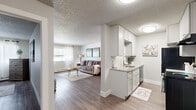 Located at 1020 S Chelton Rd in Colorado Springs, CO, this 2-bedroom, 1-bathroom home offers a well-designed single-floor layout that maximizes every square foot. The open-concept living and kitchen area creates a seamless flow, with durable wood-style flooring running throughout and a neutral color palette that lends a clean, cohesive feel.

The kitchen features white shaker-style cabinetry, granite-look countertops, a stainless steel sink, and black appliances including an electric range and refrigerator, complemented by a range hood and ample upper cabinet storage. A half-wall peninsula connects the kitchen to the living area, enhancing the open feel.

The living room is bright and welcoming, with windows that allow natural light to fill the space and a baseboard heating system along the exterior wall. The textured ceiling is consistent throughout the home.

The primary bedroom is a generously sized retreat, featuring large windows with sheer curtains and hardwood-style flooring. The second bedroom offers a comfortable layout with similar finishes. The full bathroom is clean and functional, with a tiled tub-shower combination, white fixtures, and granite-style countertops. This home delivers practical comfort with modern touches in a convenient Colorado Springs location.