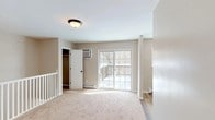 Located at 4676 Albany Post Rd in Hyde Park, NY, this 2-bedroom, 1-bathroom unit offers a well-organized single-floor layout with a clean, neutral aesthetic throughout. The living area features soft carpeting and a sliding glass door that opens to a private deck, allowing natural light to fill the space while providing views of the surrounding wooded scenery. A white-railed staircase adds a classic architectural touch to the entry area.

The kitchen is equipped with stainless steel appliances, including a full-size refrigerator and built-in microwave, complemented by white cabinetry, light countertops, and a distinctive herringbone-patterned tile backsplash. Hardwood-style flooring runs through the kitchen and adjoining areas, creating a warm contrast to the carpeted rooms.

Both bedrooms are generously proportioned, carpeted, and finished in soft neutral tones. Each room benefits from natural light through grid-pane windows and is served by baseboard heating. One bedroom features a closet with bifold doors, while the other includes a walk-in closet with wall-mounted AC. The full bathroom is tastefully updated with dark tile flooring, marble-style shower surround, and a window that brings in natural light.