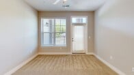 This well-appointed two-bedroom, one-bathroom residence in Charlotte, NC offers a thoughtfully designed single-level layout with a clean, modern aesthetic throughout. The open-concept kitchen and living area serves as the heart of the home, featuring white shaker cabinetry, a subway tile backsplash, stainless steel appliances including a refrigerator, range, and microwave, and a granite-topped peninsula with pendant lighting and an undermount double sink — ideal for both cooking and entertaining. Durable wood-look flooring runs through the kitchen and main areas, transitioning to plush carpet in the living and bedroom spaces. The spacious primary bedroom offers dual windows with lush outdoor views and a ceiling fan, while a dedicated closet provides wire shelving for organized storage. The second bedroom is equally comfortable, featuring its own ceiling fan and natural light. The full bathroom is finished with a granite vanity, white cabinetry, wood-look flooring, and a tub-shower combination. A dedicated in-unit laundry room houses a full-size Whirlpool washer and dryer with overhead shelving. Neutral warm-toned walls and abundant natural light throughout create a bright, inviting atmosphere.