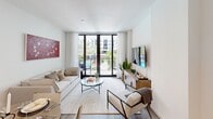 Located in Miramar, FL, this thoughtfully designed unit offers a comfortable and contemporary living experience across a single floor. The open-plan kitchen and living room serve as the heart of the space, maximizing functionality and flow. The kitchen is outfitted with sleek, light wood flat-panel cabinetry extending to the ceiling, stainless steel appliances including a French door refrigerator, built-in oven, microwave, dishwasher, and a wine cooler. A central island with a clean white quartz countertop provides additional workspace and casual seating. Light wood-style flooring runs throughout, lending warmth to the modern aesthetic. The living area is bright and airy, featuring floor-to-ceiling glass doors that open onto a private balcony overlooking a lush, resort-style courtyard complete with a large pool, palm trees, and tropical landscaping. Natural light fills the space generously. The bathroom features a clean, all-white tiled tub-shower combination with a rainfall showerhead, maintaining a crisp, minimal design. A dedicated closet provides practical storage. The overall ambiance is contemporary and polished, ideal for those seeking a well-appointed residence in a vibrant South Florida community.