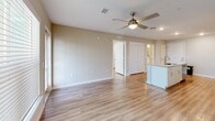 Located at 5004 Dream Dr in Winter Haven, FL, this single-story, 1-bedroom, 1-bathroom home offers a thoughtfully designed layout with contemporary finishes throughout. Light-toned wood-look flooring flows seamlessly across every room, creating a clean and cohesive aesthetic.

The open-concept kitchen and living area serves as the heart of the home. The kitchen is equipped with stainless steel appliances — including a refrigerator, electric range, and over-the-range microwave — complemented by crisp white shaker cabinetry and granite-look countertops. A peninsula with an undermount sink provides additional prep space and casual seating potential, opening directly to the living area. The living room features a ceiling fan with light fixture, neutral-toned walls, and windows with blinds that bring in natural light.

The bedroom is a comfortable, well-sized room with a large window offering outdoor views and a dedicated walk-in closet with wire shelving for organized storage. The full bathroom includes a tub/shower combination with white tile surround, a white vanity with granite-look countertop, and wood-look flooring. The space also benefits from an exterior-facing door in the living area, further enhancing natural light and access.