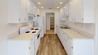 This single-floor residence offers a clean, functional layout across two bedrooms and two bathrooms, designed with practicality and comfort in mind. The open living area features neutral carpet flooring and recessed lighting, seamlessly connecting to a hallway that leads to the private quarters. A ceiling fan provides additional comfort in the living space, which receives natural light from a window.

The galley-style kitchen is well-equipped with white cabinetry, light countertops, recessed ceiling lights, and wood-look flooring. White appliances—including a range, microwave, and refrigerator—are provided, and the kitchen leads directly to a dedicated pantry for added storage.

Both bedrooms are carpeted and feature ceiling fans with built-in lighting and windows fitted with blinds. Each room offers closet storage, and one bedroom includes an expanded closet area with multiple hanging rods.

The two bathrooms maintain a consistent, clean aesthetic with white cabinetry, light countertops, and wood-look flooring. One bathroom features a shower-tub combination, while the second is equipped with a walk-in glass-door shower. Both include vanity mirrors and ample under-sink storage.