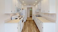 This single-floor residence offers a clean, functional layout across two bedrooms and two bathrooms, designed with practicality and comfort in mind. The open living area features neutral carpet flooring and recessed lighting, seamlessly connecting to a hallway that leads to the private quarters. A ceiling fan provides additional comfort in the living space, which receives natural light from a window.

The galley-style kitchen is well-equipped with white cabinetry, light countertops, recessed ceiling lights, and wood-look flooring. White appliances—including a range, microwave, and refrigerator—are provided, and the kitchen leads directly to a dedicated pantry for added storage.

Both bedrooms are carpeted and feature ceiling fans with built-in lighting and windows fitted with blinds. Each room offers closet storage, and one bedroom includes an expanded closet area with multiple hanging rods.

The two bathrooms maintain a consistent, clean aesthetic with white cabinetry, light countertops, and wood-look flooring. One bathroom features a shower-tub combination, while the second is equipped with a walk-in glass-door shower. Both include vanity mirrors and ample under-sink storage.