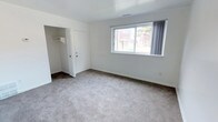 This two-story townhome offers three bedrooms and one full bathroom, thoughtfully laid out across two floors. The kitchen is equipped with warm oak cabinetry, ample upper and lower cabinet storage, a double sink, and white appliances including a range, dishwasher, and refrigerator. Light pours in through multiple windows, and the kitchen's light wood-style vinyl plank flooring adds a clean, durable finish. A wall unit air conditioner provides climate control on the main level.

The full bathroom features white tile surround in the tub-shower combination, a pedestal-style sink with chrome fixtures, and a window that allows natural light into the space. The bathroom flooring transitions between tile and wood-style vinyl.

Each of the three bedrooms is finished with plush carpet and neutral white walls, creating a bright and comfortable atmosphere. The bedrooms are well-sized, each offering a closet with built-in shelving or hanging rods for storage. Windows in each bedroom frame views of the surrounding neighborhood and greenery, filling the rooms with natural light. A carpeted staircase with a white handrail connects the two floors, contributing to the townhome's cohesive and practical design throughout.