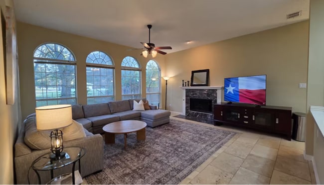 Morning light spills through floor-to-ceiling windows in this first-floor family room - 10913 Alexandria Dr