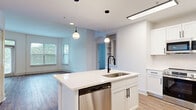 Located at 1924 Monroe Dr NE in Atlanta's vibrant Morningside neighborhood, this 2-bedroom, 3-bathroom residence offers a well-designed, single-floor layout with a clean, modern aesthetic throughout. Warm hardwood-style flooring flows seamlessly from room to room, complementing the bright white walls and crisp trim work.

The open-concept kitchen and living area serves as the heart of the home. The kitchen is outfitted with white shaker cabinetry accented by matte black hardware, a herringbone tile backsplash, stainless steel appliances including a gas range, microwave, and refrigerator, and a central island with a sink and pendant lighting overhead. The adjoining living room is bathed in natural light from large windows and a sliding glass door with views of lush greenery, and features a graceful arched entryway as a subtle architectural detail.

Both bedrooms are comfortably sized, offering hardwood-style flooring, natural light from windows, and convenient closet access. The primary bedroom includes an en-suite bathroom, while additional bathrooms serve the second bedroom and guests. The bathrooms feature white subway tile surrounds in the tub/shower combinations, white vanities with matte black fixtures, and wood-look flooring, creating a cohesive and polished look. Two dedicated closets provide ample storage throughout the unit.