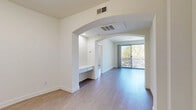 Located at 9850 Zelzah Avenue in the Northridge neighborhood of Los Angeles, this 2-bedroom, 2-bathroom unit offers a well-organized, single-level layout with a clean, modern aesthetic throughout. Light wood-style flooring flows consistently across all rooms, contributing to a bright and cohesive interior.

The living area is defined by a striking arched doorway that opens into a spacious main room filled with natural light. Large sliding glass doors lead to a private balcony with outdoor seating, providing pleasant views of mature trees and the surrounding neighborhood.

The galley-style kitchen features white cabinetry, white countertops, a stainless steel refrigerator, and a dishwasher, offering an efficient and functional workspace with ample storage.

The generously sized primary bedroom benefits from natural light via vertical-blind-fitted windows, while the second bedroom also receives good natural light and offers comfortable proportions. A dedicated closet provides additional storage.

Both bathrooms are finished with white vanities, large mirrors, and tub-shower combinations with sliding glass enclosures, maintaining the clean, neutral palette found throughout the unit. The overall ambiance is bright, airy, and move-in ready, with a minimalist design that lends itself to a variety of interior styles.