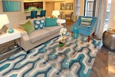 This well-appointed single-floor residence at 550 St. Michaels Way in Newport News, Virginia offers a thoughtfully designed layout with a cohesive teal and neutral color palette throughout. The living room serves as a central gathering space, highlighted by a striking stone-surround fireplace, rich hardwood-style flooring, and direct access to an in-unit washer and dryer closet. The kitchen features dark espresso cabinetry, granite-look countertops, a double stainless steel sink with a pull-down faucet, a built-in dishwasher, and a vibrant teal accent wall that adds a pop of color. The bedroom is a serene retreat, complete with plush carpeting, a ceiling fan, a decorative accent wall, and a generous walk-in closet with wire shelving. A bay window configuration floods the bedroom with natural light and provides access to an outdoor area via a private door. The bathroom is clean and functional, offering a full soaking tub with a tiled shower surround and chrome fixtures. Throughout the space, consistent design choices — including teal drapery, layered lighting, and tasteful artwork — create a warm, cohesive ambiance well-suited for comfortable everyday living.