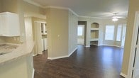 Located at 205 Benton Dr. in Allen, Texas, this single-story home offers a well-designed, open layout that maximizes the sense of space throughout. The living area is a standout feature, showcasing rich, dark hardwood-style flooring that runs seamlessly through the main areas, creating a warm and cohesive aesthetic. Crown molding throughout adds a refined architectural touch, while neutral warm-toned walls provide a versatile backdrop for any décor style. A defining feature of the living room is the built-in arched shelving unit, offering both display space and a classic design element that enhances the room's character. Natural light flows in through multiple windows, brightening the open floor plan and highlighting the clean lines of the interior. A dedicated in-unit laundry area with side-by-side washer and dryer connections offers everyday convenience. The home's single-floor design ensures easy accessibility and a smooth traffic flow between rooms. The combination of classic detailing, quality finishes, and functional layout makes this Allen, Texas home a well-rounded and inviting living space.