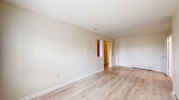 Located at 554 Connecticut Ave in Norwalk, Connecticut, this single-floor residence offers three bedrooms, one bathroom, a living room, and a kitchen across a well-organized layout. Light-toned hardwood flooring flows throughout the main living areas and bedrooms, creating a clean, cohesive aesthetic complemented by neutral wall tones throughout.

The living room is a bright, open space featuring sliding glass doors that lead to a private balcony overlooking lush greenery, filling the room with natural light. The kitchen is well-appointed with warm wood cabinetry, granite countertops, tile flooring, and a full suite of stainless steel appliances including a refrigerator, range, microwave, and dishwasher.

The generously sized primary bedroom features dual closets, providing ample storage. The additional bedrooms are comfortably proportioned, each with closet space and windows that bring in natural light and neighborhood views. Baseboard heating is present throughout the unit.

The bathroom is finished with marble-style tile flooring, a white vanity, and a full tub-shower combination, maintaining the clean and functional character found throughout the residence. Overall, the space presents a practical and well-maintained living environment in a convenient Norwalk location.
