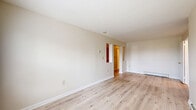Located at 554 Connecticut Ave in Norwalk, Connecticut, this single-floor residence offers three bedrooms, one bathroom, a living room, and a kitchen across a well-organized layout. Light-toned hardwood flooring flows throughout the main living areas and bedrooms, creating a clean, cohesive aesthetic complemented by neutral wall tones throughout.

The living room is a bright, open space featuring sliding glass doors that lead to a private balcony overlooking lush greenery, filling the room with natural light. The kitchen is well-appointed with warm wood cabinetry, granite countertops, tile flooring, and a full suite of stainless steel appliances including a refrigerator, range, microwave, and dishwasher.

The generously sized primary bedroom features dual closets, providing ample storage. The additional bedrooms are comfortably proportioned, each with closet space and windows that bring in natural light and neighborhood views. Baseboard heating is present throughout the unit.

The bathroom is finished with marble-style tile flooring, a white vanity, and a full tub-shower combination, maintaining the clean and functional character found throughout the residence. Overall, the space presents a practical and well-maintained living environment in a convenient Norwalk location.