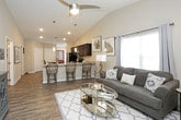 This single-story residence offers a thoughtfully designed layout that balances comfort and functionality across its living spaces. The open-concept living and dining area serves as the heart of the home, featuring wood-look plank flooring, vaulted ceilings with ceiling fans, and generous natural light provided by large windows dressed with blinds and curtains. The adjoining dining space accommodates a full-sized table and connects seamlessly to the rest of the home via sliding glass doors.

The kitchen is well-equipped with rich dark cabinetry, granite-style countertops, stainless steel appliances including a refrigerator, range, and microwave, plus a double-basin sink and a breakfast bar with seating. A dedicated island provides additional workspace.

The bedroom features plush wall-to-wall carpeting, multiple windows, and a ceiling fan, creating a calm and comfortable retreat. Two full bathrooms serve the home; one includes a soaking tub and shower combination, while the other offers a standalone walk-in shower. Both bathrooms are finished with dark wood vanities and light stone countertops atop wood-look flooring. A dedicated laundry area with a full-sized washer and dryer and overhead cabinetry adds practical convenience.