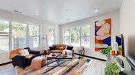 Located at 808 Melvin Ct in Madison, WI, this well-designed single-floor unit offers a thoughtful layout across one bedroom, two full bathrooms, and a dedicated office space. The open-concept kitchen and living area serves as the heart of the home, featuring light wood cabinetry, stainless steel appliances including a refrigerator and range, and a large central island with seating — ideal for dining and entertaining. Pendant lighting and recessed fixtures illuminate the space, which flows seamlessly into the living room. The living room is bright and airy, with oversized windows that frame views of the surrounding neighborhood and flood the interior with natural light. Light wood-tone flooring runs consistently throughout the unit, contributing to a clean, cohesive aesthetic. The bedroom offers a ceiling fan, a large closet with sliding doors, and a window with outdoor views. Both bathrooms are finished with wood-toned vanities and white countertops; one includes a walk-in shower with tile flooring, while the other features warm, neutral tones. The dedicated office provides a quiet retreat with its own large window and ample natural light — a functional bonus space well-suited for remote work or study.