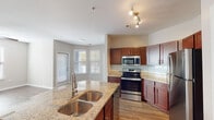 Located at 5741 Goodstone Dr in Raleigh, NC, this single-floor residence offers a well-designed layout that balances comfort and functionality. The kitchen serves as the heart of the home, showcasing rich cherry wood cabinetry, light granite countertops with a double stainless steel sink, and a full suite of stainless steel appliances including a refrigerator, range, and built-in microwave. A subway tile backsplash adds a clean, contemporary touch, while wood-look flooring and track lighting complete the polished look. The kitchen flows seamlessly into the living and dining areas, with a bay window inviting generous natural light throughout.

The bedrooms are carpeted for warmth and comfort, each featuring ceiling fans, window blinds for privacy, and access to well-sized closets. The primary bedroom includes a spacious walk-in closet outfitted with wire shelving and hanging rods for ample storage. The bathrooms are thoughtfully appointed with soaking tubs and shower combinations, chrome fixtures, and neutral toned walls that create a calm, relaxing atmosphere. One bathroom also features a safety grab bar, adding an element of accessibility. Throughout the residence, neutral paint tones and consistent finishes create a cohesive and inviting ambiance.
