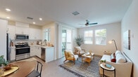 Located at 3310 W 84th St in Inglewood, California, this two-story residence offers a thoughtfully designed layout with modern finishes and a warm, neutral aesthetic throughout. The main level features an open-concept living and dining area filled with natural light from large windows fitted with plantation shutters. A ceiling fan adds comfort to the inviting living space, which opens onto a private balcony through sliding glass doors. The adjacent dining area is anchored by a staircase leading to the upper level. The kitchen is well-appointed with white shaker cabinetry, stainless steel appliances including a refrigerator, range, microwave, and dishwasher, complemented by clean countertops and wood-look flooring. A full bathroom on the lower level features a white vanity with gold-toned fixtures and a tiled shower. Upstairs, the bedrooms are carpeted and bathed in natural light, each equipped with ceiling fans and generous windows with views of surrounding greenery. The primary bathroom is spacious, featuring a dual-sink vanity, a walk-in glass-enclosed shower with tile surround, and wood-look flooring accented by clerestory windows. The overall ambiance is clean, contemporary, and welcoming, ideal for comfortable everyday living.