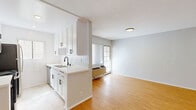 This 420 square foot studio apartment, located in Los Angeles, offers a thoughtfully designed living space on a single floor. The open-plan layout maximizes the use of space, creating a sense of openness and flow. The living area is characterized by its warm, honey-toned wood flooring, which extends throughout the space, providing a cohesive and inviting atmosphere.

The apartment features recessed lighting and large windows, ensuring ample natural light floods the interior. The kitchen, while compact, is efficiently designed with white cabinetry and black appliances, creating a modern contrast. A partial wall cleverly separates the kitchen from the main living area without compromising the open feel.

The bathroom showcases a clean, contemporary design with a white color palette. It includes a spacious bathtub-shower combination with a curved shower rod, enhancing the sense of space. Black fixtures add a touch of elegance against the crisp white surfaces.

Storage solutions are integrated throughout, including mirrored sliding closet doors that serve dual purposes of storage and visually expanding the space. The apartment's neutral color scheme, primarily whites and light grays, contributes to a bright and airy ambiance, making the compact space feel larger and more open.