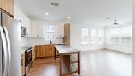 Located at 1290 Old Peachtree Rd NW in Duluth, Georgia, this modern single-floor residence offers a well-designed layout with contemporary finishes throughout. The open-concept kitchen is a standout feature, showcasing a two-tone cabinet design with white upper cabinetry and warm wood-grain lower cabinets, granite countertops, a subway tile backsplash, stainless steel appliances, and a movable island with a stainless steel top — providing both style and functionality. Recessed lighting and multiple windows flood the space with natural light.

The living areas feature warm hardwood-style flooring, while the bedrooms are finished with plush carpeting for added comfort. Bedrooms are generously sized, with large windows, ceiling fans, and ample natural light. One bedroom provides direct access to a private balcony, offering outdoor views of the surrounding community.

The bathrooms are thoughtfully appointed, featuring wood-grain vanities, granite countertops, and wood-style flooring. One bathroom includes a glass-enclosed shower, while another offers a full tub-and-shower combination. Dark, paneled interior doors add a rich contrast to the bright white walls throughout. Hallways are clean and well-lit with recessed lighting, contributing to the overall modern and inviting ambiance of this move-in-ready residence.