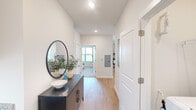 Located in Huntsville, AL, this thoughtfully designed 2-bedroom, 2-bathroom single-story residence combines modern aesthetics with functional living. The interior is defined by a clean, neutral palette featuring crisp white walls, light wood-style flooring throughout the main areas, and an abundance of natural light from well-placed windows fitted with white blinds.

The welcoming hallway sets the tone with recessed lighting and a sense of openness that carries through the entire floor plan. The living area features a glass-paneled exterior door that fills the space with natural light and provides direct outdoor access, offering views of the surrounding community.

Both bedrooms are generously proportioned, carpeted for comfort, and equipped with ceiling fans. The primary bedroom includes an ensuite bathroom and a dedicated closet, while the second bedroom is similarly well-appointed with its own closet. The primary bath features a glass-enclosed walk-in shower, while the secondary bath offers a tub-shower combination — both finished with granite-topped vanities, gray cabinetry, and tile flooring.

The layout is completed by a central hallway that connects all spaces efficiently, providing a cohesive and comfortable flow throughout this well-appointed Huntsville residence.
