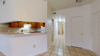 Located at 717 Hill Country Dr in Kerrville, Texas, this single-story home offers a functional and comfortable layout suited to everyday living. The living room serves as the heart of the home, highlighted by a classic brick corner fireplace, light tile flooring, a ceiling fan, and French doors that open to the outdoors, allowing for ample natural light. Adjacent to the living area, the kitchen features warm wood cabinetry, a tile backsplash, electric range, full-size refrigerator, and a pass-through breakfast bar that connects seamlessly to the dining and entry areas — all finished with the same light tile flooring for a cohesive look. A wide hallway leads from the main living area to the private quarters of the home. The bedrooms are carpeted and include ceiling fans and windows that bring in natural light, with one room featuring direct exterior door access. Two full bathrooms are finished with tile flooring, wood vanities with white countertops, and tub/shower combinations with tiled surrounds. The overall palette throughout the home is light and neutral, contributing to a clean and airy atmosphere well-suited to the Texas Hill Country setting.