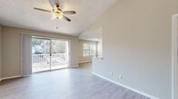 This single-floor residence offers a thoughtfully designed open layout that connects the living, dining, and kitchen areas seamlessly. The living room is bright and airy, featuring light-toned luxury vinyl plank flooring, a ceiling fan, and a textured ceiling. A sliding glass door opens to a private balcony, flooding the space with natural light and providing outdoor views of the surrounding neighborhood.

The kitchen is well-equipped with white cabinetry, granite countertops, a tile backsplash, and a full suite of stainless steel appliances, including a range, microwave, dishwasher, and refrigerator. A pass-through window connects the kitchen to the adjacent dining or living area, enhancing the open feel of the home.

The dining area shares the same light flooring and benefits from a secondary window, offering additional natural light. Both bedrooms are carpeted and generously sized, each featuring a ceiling fan and windows with blinds that allow for adjustable light and privacy.

The bathroom is clean and functional, with granite-topped vanity cabinetry, a tiled shower-tub combination, wood-look tile flooring, and neutral walls. The overall palette throughout the space is warm and neutral, creating a cohesive, welcoming ambiance that is move-in ready.