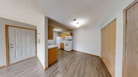 Located at 2041 W Bingham St in Ozark, Missouri, this single-floor, 2-bedroom, 2-bathroom home offers a practical and well-organized layout. Throughout the main living areas, durable wood-style flooring runs underfoot, complemented by neutral gray walls and textured ceilings that lend a clean, consistent aesthetic.

The living room is a bright, open space featuring a sliding glass door that leads to a private outdoor deck, allowing natural light to fill the room. The adjacent combined kitchen and dining area is equipped with warm oak cabinetry, white appliances including a refrigerator, electric range, and built-in microwave, along with a functional sink and ample counter space.

A connecting hallway leads to both bedrooms. The primary bedroom offers generous proportions, plush carpeting, and closet storage. The second bedroom also features carpet flooring, a natural light-admitting window, and its own closet. Three closets are distributed throughout the home, providing notable storage capacity.

Both bathrooms are finished with wood-toned vanities, single-basin sinks, and full tub/shower combinations with chrome fixtures and wood-style flooring. A dedicated laundry area and utility room add further convenience. The overall layout is efficient and functional, making this home a well-appointed option in Ozark, MO.