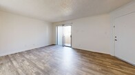 Located at 3515 E Bell Rd in Phoenix, Arizona, this two-story residence offers two bedrooms and two bathrooms across a well-organized layout divided evenly between both floors. The main level features a living room with wood-style plank flooring, white walls, and a textured ceiling, with a staircase leading to the upper level. A sliding glass door opens from the living area to a private patio, bringing in natural light. The galley-style kitchen is equipped with black appliances, including an electric range and refrigerator, complemented by light wood cabinetry, laminate countertops, and a range hood. A dedicated laundry area with hookups and shelving above provides added convenience. One bathroom on the main floor includes a vanity with oak cabinetry and wood-style flooring. Upstairs, both bedrooms are carpeted and feature ceiling fans with light fixtures and windows allowing natural light. The primary bedroom offers a generous footprint with closet access. The second upstairs bathroom includes a tub-shower combination. A pantry, hallway, and two closets round out the functional layout of this efficiently designed home.