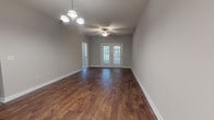 Located at 2109 Oglethorpe Circle in Pooler, Georgia, this single-story home offers a thoughtfully designed layout with a variety of attractive finishes throughout. The entryway immediately sets an elegant tone, showcasing detailed wainscoting panels, crown molding, and light tile flooring, creating a welcoming first impression. A transom window above the front door allows natural light to fill the foyer.

The main living area transitions to rich, dark hardwood-style flooring and features a ceiling fan and chandelier combination, with French doors at the rear providing views and additional natural light. An adjacent dining or flex area flows seamlessly toward the kitchen, which is equipped with warm honey-toned wood cabinetry, granite-look countertops, a double stainless steel sink, and tile flooring — all complemented by a window overlooking the outdoors.

The bedrooms offer plush carpeting and multiple windows that invite natural light, providing comfortable and versatile spaces. The primary bathroom includes a dedicated walk-in shower with built-in shelving and a single vanity with wood cabinetry. Secondary bathrooms feature a tub-shower combo with tile surround, a wood vanity, and tile flooring, maintaining a consistent and clean aesthetic throughout the home.