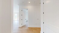 Located in Oakmont, PA, this thoughtfully designed single-floor home offers six bedrooms, four bathrooms, and an impressive layout that balances comfort and style. Throughout the home, light hardwood flooring and crisp white walls create a clean, contemporary aesthetic, complemented by crown molding and Shaker-style interior doors with matte black hardware.

The open living area is bathed in natural light, with floor-to-ceiling windows overlooking a covered balcony and sweeping views of the river and lush, tree-lined hills beyond — a truly standout feature of the property. The balcony itself is generously sized with a sleek metal railing, offering an ideal setting for outdoor relaxation.

The galley-style kitchen is efficiently designed with white shaker cabinetry extending to the ceiling, quartz countertops, a subway tile backsplash, and stainless steel appliances, including a range, dishwasher, and refrigerator. A window at the end of the kitchen frames additional outdoor views.

The spacious primary bedroom provides a serene retreat, while the additional bedrooms feature plush carpeting and ample natural light. The bathrooms are finished with large-format tile flooring, white vanities, and clean, modern fixtures. A dedicated laundry room with tile flooring and a bright window adds everyday convenience to this well-appointed home.