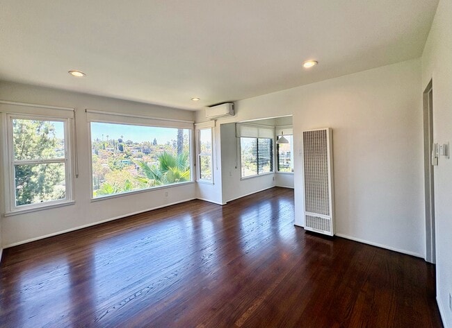 A dramatic wall of picture windows fills the living room with natural light. - 1672 Rotary Dr