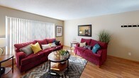 This single-floor residence offers a thoughtfully designed layout with a welcoming living room, kitchen, bedrooms, and bathroom. The living room serves as the heart of the home, featuring warm hardwood flooring, a textured ceiling, and a large window with vertical blinds that allows generous natural light to fill the space. A decorative wall mirror adds depth and brightness to the room's open feel.

The kitchen is efficiently arranged with warm wood cabinetry, dark granite countertops, tile flooring, and a full suite of black appliances including a range, over-the-range microwave, refrigerator, and dishwasher — providing everything needed for everyday cooking.

The primary bedroom offers a comfortable retreat with plush carpeting, a window with vertical blinds, and a spacious closet fitted with mirrored sliding doors that reflect light and add a sense of openness. A secondary bedroom mirrors this comfortable style, also featuring carpeted flooring, a large window, and warm neutral tones throughout.

A hallway bathroom is finished with tile flooring, a shower/tub combination, a single vanity with a white sink, and a mirrored medicine cabinet. Additional built-in closet storage is conveniently accessible from the hallway. Throughout the residence, neutral warm-toned walls and consistent wood trim details create a cohesive and inviting atmosphere.