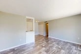 Located at 7200 Powers Ave in Jacksonville, FL, this two-bedroom, one-bathroom single-floor residence offers a practical and comfortable layout. Wood-look plank flooring runs throughout the home, complementing the neutral gray walls and textured ceilings found in most rooms. The open-concept living, dining, and kitchen area forms the heart of the home. The kitchen is equipped with white cabinetry, light granite-style countertops, a full suite of white appliances including a range, dishwasher, and refrigerator, and ample overhead storage. A sliding glass door in the living/dining area opens directly to a private patio overlooking a green lawn, bringing in natural light and outdoor access. Both bedrooms offer generous space, with the primary bedroom providing a comfortable retreat. Four closets are distributed throughout the unit, offering notable storage capacity. A hallway connects the main living areas to the bedrooms and the full bathroom, which features a combined tub-shower with white tile surround and chrome fixtures. The single-floor layout ensures easy accessibility, and the overall design is clean, functional, and move-in ready.