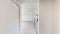 Located at 1529 N Fremont St in Chicago's vibrant Lincoln Park neighborhood, this one-bedroom, one-bathroom unit offers a thoughtfully designed layout that maximizes every inch of its compact footprint. Light wood-tone flooring runs throughout the space, lending warmth and visual continuity across all rooms.

The spacious bedroom serves as the heart of the unit, featuring crisp white walls, a large window that draws in natural light and provides views of the surrounding streetscape, and a full-width built-in closet with sleek white bi-fold doors and matte black hardware — offering generous storage in a clean, modern aesthetic.

The bathroom is well-appointed with a warm wood-toned vanity topped with a white countertop, a backlit LED mirror, and a striking tiled shower enclosure featuring a green and white checkered pattern that adds a bold design accent against the otherwise minimalist white walls. Matte black fixtures provide a cohesive finishing touch throughout.

The overall layout, visible in the overhead dollhouse view, includes a compact kitchen area and hallway connecting the main living spaces efficiently. The unit's clean lines, neutral palette, and modern finishes make it a functional and stylish option in one of Chicago's most sought-after neighborhoods.
