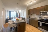 Located in San Jose, CA, this single-floor, 2-bedroom, 3-bathroom residence offers a thoughtfully designed open-concept layout. The kitchen is a standout feature, showcasing rich dark wood cabinetry, stainless steel appliances, a subway tile backsplash, and a central island with bar seating — all illuminated by elegant pendant lighting and track lights. It flows seamlessly into the bright living room, which is filled with natural light from large windows and features a ceiling fan and access to a private balcony. The primary bedroom includes plush carpeting, a well-organized walk-in closet with wire shelving, and an en-suite bathroom with a dual-sink vanity, dark wood cabinetry, white quartz countertops, and marble-style tile flooring. An in-unit stacked washer and dryer add everyday convenience. The second bedroom offers comfortable carpeting, a large window, and a charming striped accent wall. Bathrooms throughout include tub-shower combinations with marble-style tile surrounds. Light wood-look flooring runs through the main living areas, lending warmth and continuity to the overall design. Two closets and two hallways round out the functional, well-organized floor plan.
