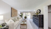 Located at 4 Westover Club Drive in Norristown, Pennsylvania, this single-floor residence offers a thoughtfully arranged layout with distinct living, dining, kitchen, and sleeping areas. The living room is generously proportioned, featuring plush carpeting, a textured ceiling, and a sliding glass door that fills the space with natural light while providing direct access to an outdoor green area. Neutral-toned walls complement the open, airy atmosphere throughout.

The kitchen is equipped with warm wood cabinetry, granite-style countertops, stainless steel appliances including a range and dishwasher, and durable wood-look flooring. A dedicated dining area features a tray ceiling detail and chair-rail molding, adding a refined architectural accent to the space.

The bedroom is carpeted and comfortably sized, with a window that admits natural light and views of the surrounding greenery. A hallway with built-in shelving connects the rooms and provides additional storage. The bathroom includes wood-look flooring, a vanity with a light countertop, and brushed nickel fixtures. Overall, the residence presents a clean, neutral palette with practical finishes throughout.