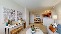 Located at 1350 Gage Street in Columbus, Ohio, this single-floor residence offers a thoughtfully designed open-concept layout that seamlessly connects the living, dining, and kitchen areas. The living room is generously sized, featuring plush wall-to-wall carpeting, neutral-toned walls, and a large window that allows natural light to fill the space. The kitchen is equipped with rich warm-toned wood cabinetry, black appliances including a range, built-in microwave, and refrigerator, along with a peninsula that provides additional counter space and separation from the dining area. The dining space accommodates a full-sized table and is positioned near an in-unit laundry closet housing a full-size washer and dryer. Both bedrooms are carpeted and comfortably proportioned. The primary bedroom benefits from multiple windows and ample natural light, while the secondary bedroom includes a spacious sliding-door closet. A bathroom features wood-tone cabinetry, a vanity with mirror, and light hardwood-style flooring. Throughout, the residence maintains a cohesive, neutral color palette that creates a calm and welcoming ambiance, making it a functional and comfortable home in the Columbus area.
