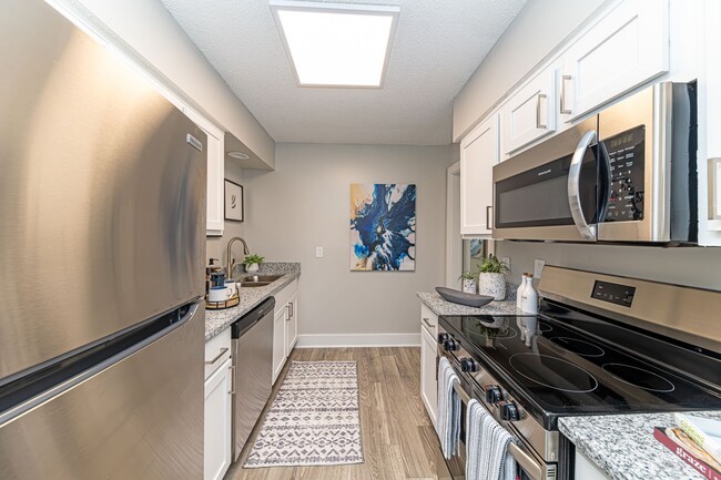 Kitchen with hardwood-style flooring, modern cabinetry and stainless appliances - Reserve at Drakes Creek