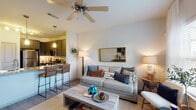 Located at Trailhouse Lane in Forney, Texas, this single-story residence offers a thoughtfully designed open-concept layout that seamlessly connects the living, dining, and kitchen areas. The living room features wood-style flooring, a ceiling fan, and large windows dressed with sheer curtains that invite natural light to fill the space, creating a bright and welcoming ambiance.

The kitchen is a standout feature, equipped with dark espresso-toned shaker cabinets, granite countertops, a subway tile backsplash, and a full suite of stainless steel appliances including a refrigerator, range, and built-in microwave. A peninsula with pendant lighting and bar seating provides a functional and stylish transition into the living area.

The bedroom is generously proportioned, with plush carpeting, a ceiling fan, and windows that allow ample natural light. It provides a calm and restful retreat with easy access to adjoining spaces.

The bathroom is finished with wood-style flooring, dark cabinetry with matching granite countertops, a tiled tub/shower combination, and clean white walls that contribute to a crisp, functional aesthetic.

Throughout the residence, consistent design choices—including matching cabinet finishes, granite surfaces, and ceiling fans—create a cohesive and polished look suitable for comfortable everyday living.