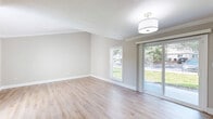 Located at 233 Country Walk Pl in Altamonte Springs, FL, this well-appointed 2-bedroom, 2-bathroom single-story home offers a comfortable and functional layout with thoughtfully updated finishes throughout. Light-toned luxury vinyl plank flooring flows seamlessly across the entire home, complemented by neutral warm-gray walls, crisp white crown molding, and clean white baseboards that give the space a fresh, cohesive look.

The open living room is bright and welcoming, featuring elevated ceilings, natural light from large windows and sliding glass doors that invite outdoor views, and a pass-through window connecting to the kitchen. The kitchen is a standout highlight, boasting white shaker-style cabinetry, quartz countertops, a subway tile backsplash, and a full suite of stainless steel Samsung appliances including a range, over-the-range microwave, and dishwasher. A dedicated in-unit laundry area with a full-size washer and dryer is conveniently tucked adjacent to the kitchen alongside additional cabinetry.

Both bedrooms are generously proportioned, featuring crown molding, natural light from windows, and ample closet space with bifold doors. The primary bedroom offers a comfortable, private retreat. Both bathrooms are clean and functional, each equipped with a full tub-shower combo and brushed nickel fixtures. A hallway connects all rooms efficiently, completing this well-designed home.