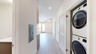 Located on Beverly Boulevard in Los Angeles, this modern 3-bedroom, 2-bathroom unit offers a thoughtfully designed single-floor layout with clean, contemporary finishes throughout. Light wood-tone flooring runs continuously through the space, complementing the crisp white walls and creating a bright, cohesive aesthetic.

The kitchen is well-appointed with two-tone cabinetry — warm natural wood uppers paired with taupe lower cabinets — white quartz countertops, a subway tile backsplash, and a full suite of stainless steel appliances including a gas range, dishwasher, microwave, and refrigerator.

The bedrooms are bright and open, with large windows that frame views of the Los Angeles skyline and palm tree-lined streetscapes. The primary bedroom benefits from generous proportions and direct access to a walk-in closet with wrap-around shelving and hanging rods. The additional bedrooms offer ample natural light and clean, neutral interiors.

Both bathrooms are finished in a minimalist style with light flooring, modern vanities, and clean white walls. One features a full soaking tub with shower, while the second offers a sleek vanity with an oversized mirror. A stacked in-unit washer and dryer is conveniently located along the hallway. Recessed lighting throughout enhances the overall bright and modern ambiance of the home.