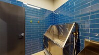Located at 27W555 High Lake Rd in Winfield, Illinois, this purpose-built Pet Spa is a single-floor facility designed to provide a fully equipped, professional-grade grooming environment. The space is immediately distinguished by its bold, glossy blue subway tile that lines the walls from floor to mid-height, creating a clean, hygienic, and visually striking aesthetic throughout.

The centerpiece of the space is a stainless steel elevated bathing tub with a built-in ramp and safety leash attachment, designed to accommodate pets of various sizes with ease and safety. A dedicated stainless steel utility sink with a standard faucet provides additional washing and rinsing capability. Professional grooming equipment is mounted directly to the tiled walls, including a high-powered blow dryer with flexible hose attachment, ensuring efficient drying and finishing.

Stainless steel work surfaces offer generous prep and grooming space, keeping tools and supplies organized and within reach. The flooring features a durable, easy-to-clean concrete finish with non-slip diamond-plate step panels at key access points. Overhead LED strip lighting ensures consistent, bright illumination across the workspace. The facility also includes clearly posted pet spa guidelines and emergency information. Access is provided through a sturdy metal door, with a secondary exit also present, ensuring safe and practical flow through the space.