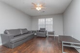 Located at Campus Pointe Circle in Gainesville, Georgia, this single-floor unit offers a practical and well-organized layout designed for comfortable everyday living. Rich, dark hardwood-style flooring flows consistently throughout the space, providing a cohesive and warm aesthetic.

The kitchen is efficiently arranged with warm oak cabinetry offering ample storage, a full suite of white appliances including a refrigerator, electric range, built-in microwave, and dishwasher, as well as a double-basin sink with generous counter space on both sides.

Adjacent to the kitchen, the dining area accommodates a full-sized table and chairs beneath a classic ceiling light fixture, and opens naturally into the living room, which features a textured ceiling and space for comfortable seating arrangements.

Both bedrooms are well-proportioned, each outfitted with ceiling fans, neutral gray walls, and dark hardwood-style flooring. One bedroom includes a double-door closet, while the other offers convenient desk space. Natural light enters through blinded windows in each room.

The unit includes two full bathrooms, each featuring a tub-shower combination, wood-tone vanity with a large mirror, and matching hardwood-style flooring. The textured ceilings are consistent throughout, giving the unit a uniform, move-in-ready appearance.