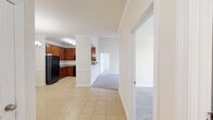 Located in Duncan, South Carolina, this 2-bedroom, 2-bathroom residence offers a thoughtfully designed single-floor layout with a warm, neutral color palette throughout. The open-concept kitchen is a standout feature, showcasing rich cherry wood cabinetry, granite countertops, tile flooring, and black appliances including a refrigerator, range, and built-in microwave. A breakfast bar peninsula connects the kitchen to the main living area, making it ideal for casual dining and entertaining. The spacious living room impresses with vaulted ceilings, a ceiling fan, crown molding, and French doors that invite natural light while providing access to an outdoor view. Both bedrooms feature soft wall-to-wall carpeting and neutral tones, with the second bedroom offering a large window with outdoor views. Each bathroom is finished with tile flooring, a tub-shower combination, and a vanity topped with granite countertops and cherry wood cabinetry. A dedicated laundry room with wire shelving and utility hookups adds everyday convenience. A closet provides additional storage to round out the functional floor plan. The consistent use of granite surfaces, rich wood tones, and tile flooring throughout lends the space a cohesive and polished aesthetic.