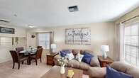 This well-appointed 1-bedroom, 1-bathroom unit in Kenner, Louisiana offers a thoughtfully designed single-story layout. The living room serves as the heart of the unit, featuring warm neutral walls, a textured ceiling, and plush carpeting. Natural light filters in through multiple windows dressed with blinds and curtain panels, while French doors open to the exterior, adding an airy quality to the space. The living area flows seamlessly into a dedicated dining nook, framed by an arched alcove and a window, creating a defined yet open feel.

The kitchen features a pass-through counter connecting it to the main living area, light wood cabinetry, a full suite of white appliances, and a tile-look countertop. Wood-look flooring at the entry transitions to carpet in the main living and sleeping areas.

The bedroom is generously sized, offering room for a full furniture arrangement. It includes a ceiling fan with light fixture, a window with natural light, and a dedicated closet. The full bathroom is equipped with a combined tub and shower, wood-look flooring, and a vanity with countertop storage. Throughout the unit, the warm, neutral color palette and consistent finishes create a cohesive and comfortable living environment.