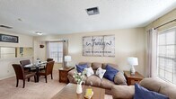 This well-appointed 1-bedroom, 1-bathroom unit in Kenner, Louisiana offers a thoughtfully designed single-story layout. The living room serves as the heart of the unit, featuring warm neutral walls, a textured ceiling, and plush carpeting. Natural light filters in through multiple windows dressed with blinds and curtain panels, while French doors open to the exterior, adding an airy quality to the space. The living area flows seamlessly into a dedicated dining nook, framed by an arched alcove and a window, creating a defined yet open feel.

The kitchen features a pass-through counter connecting it to the main living area, light wood cabinetry, a full suite of white appliances, and a tile-look countertop. Wood-look flooring at the entry transitions to carpet in the main living and sleeping areas.

The bedroom is generously sized, offering room for a full furniture arrangement. It includes a ceiling fan with light fixture, a window with natural light, and a dedicated closet. The full bathroom is equipped with a combined tub and shower, wood-look flooring, and a vanity with countertop storage. Throughout the unit, the warm, neutral color palette and consistent finishes create a cohesive and comfortable living environment.